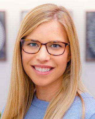 Amy Kurcz smiling, wearing glasses